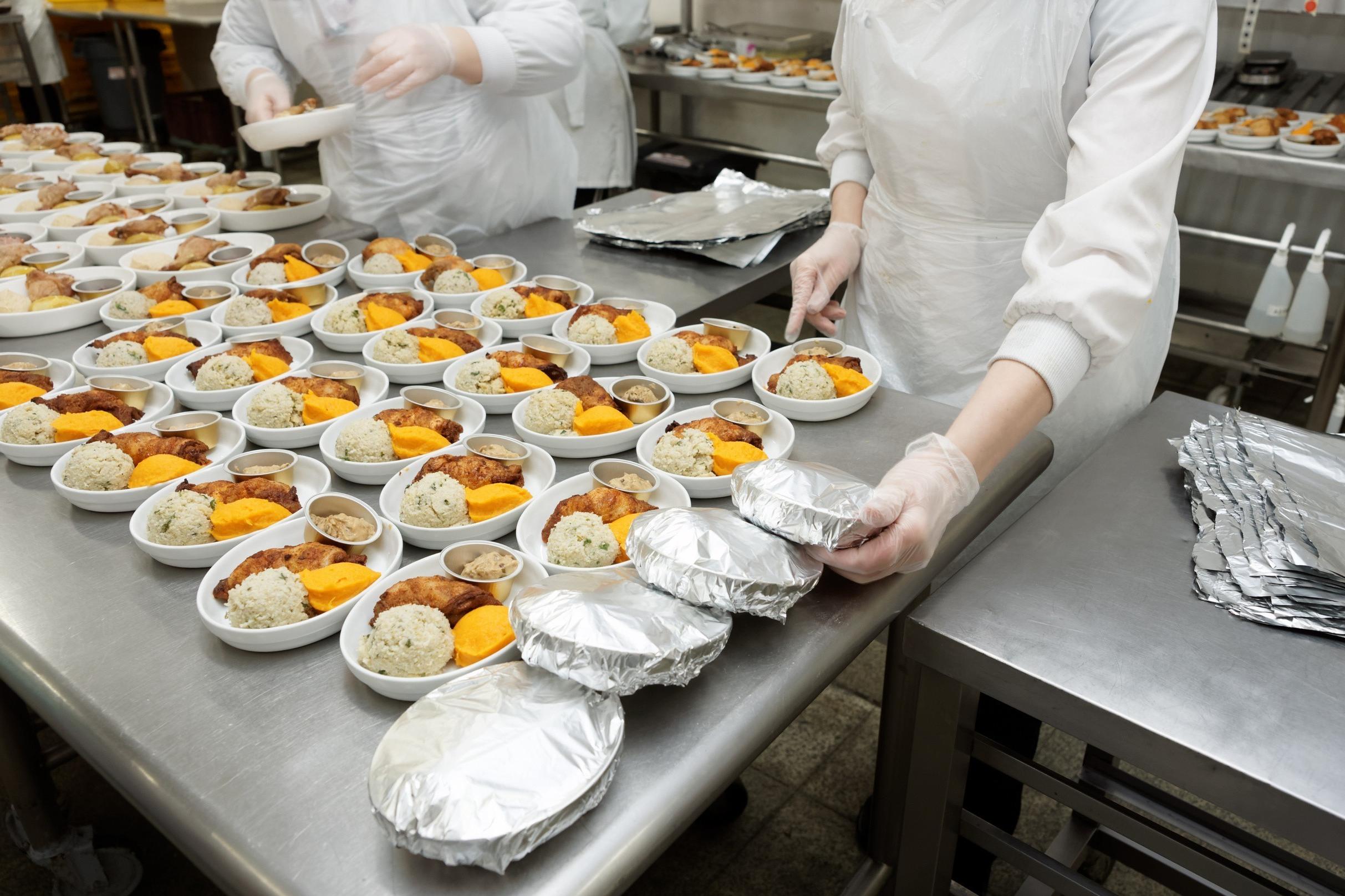 kitchen workers preparing packaged meals